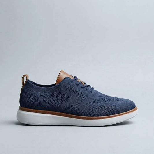 The sneaker in Navy — top view showing engineered knit upper and leather tongue