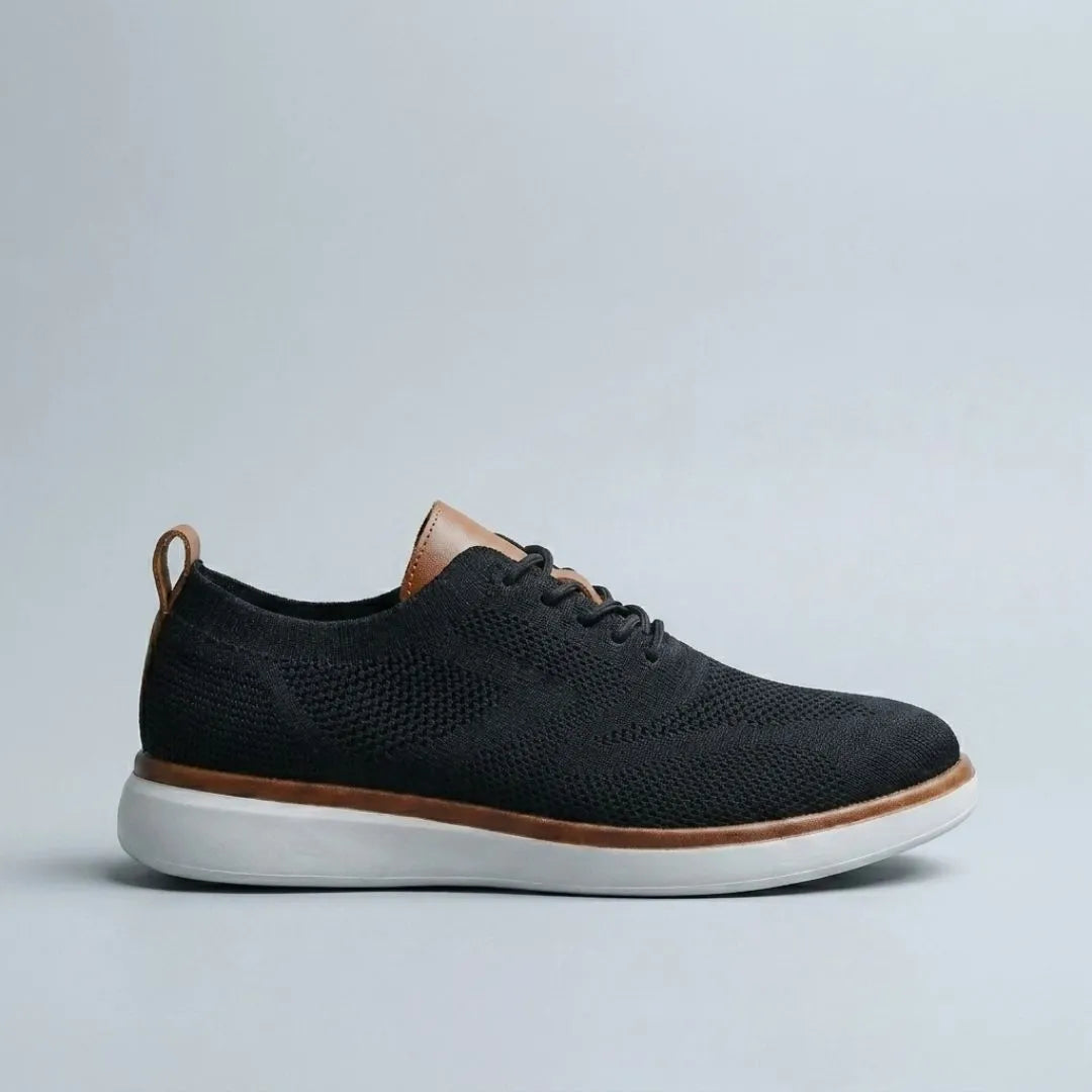 The Cottesloe sneaker in black — side view showing engineered knit upper and leather tongue